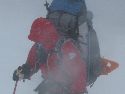 A person with massive pack in a blizzard